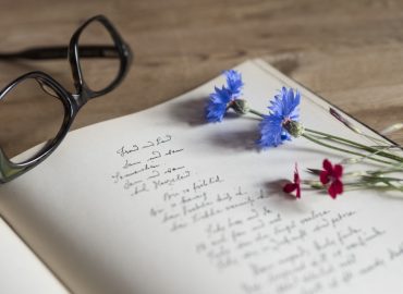 libro manuscrito con gafas y flores