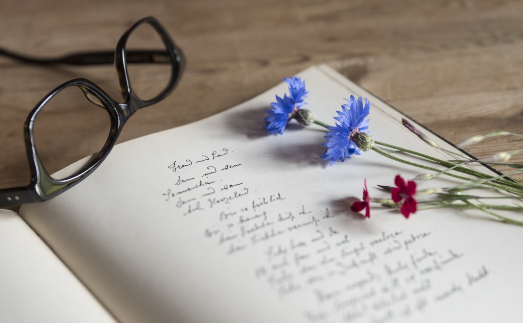 libro manuscrito con gafas y flores