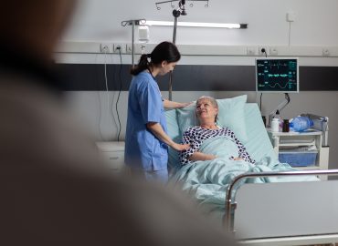 Sanitaria atendiendo a una paciente hospitalizada