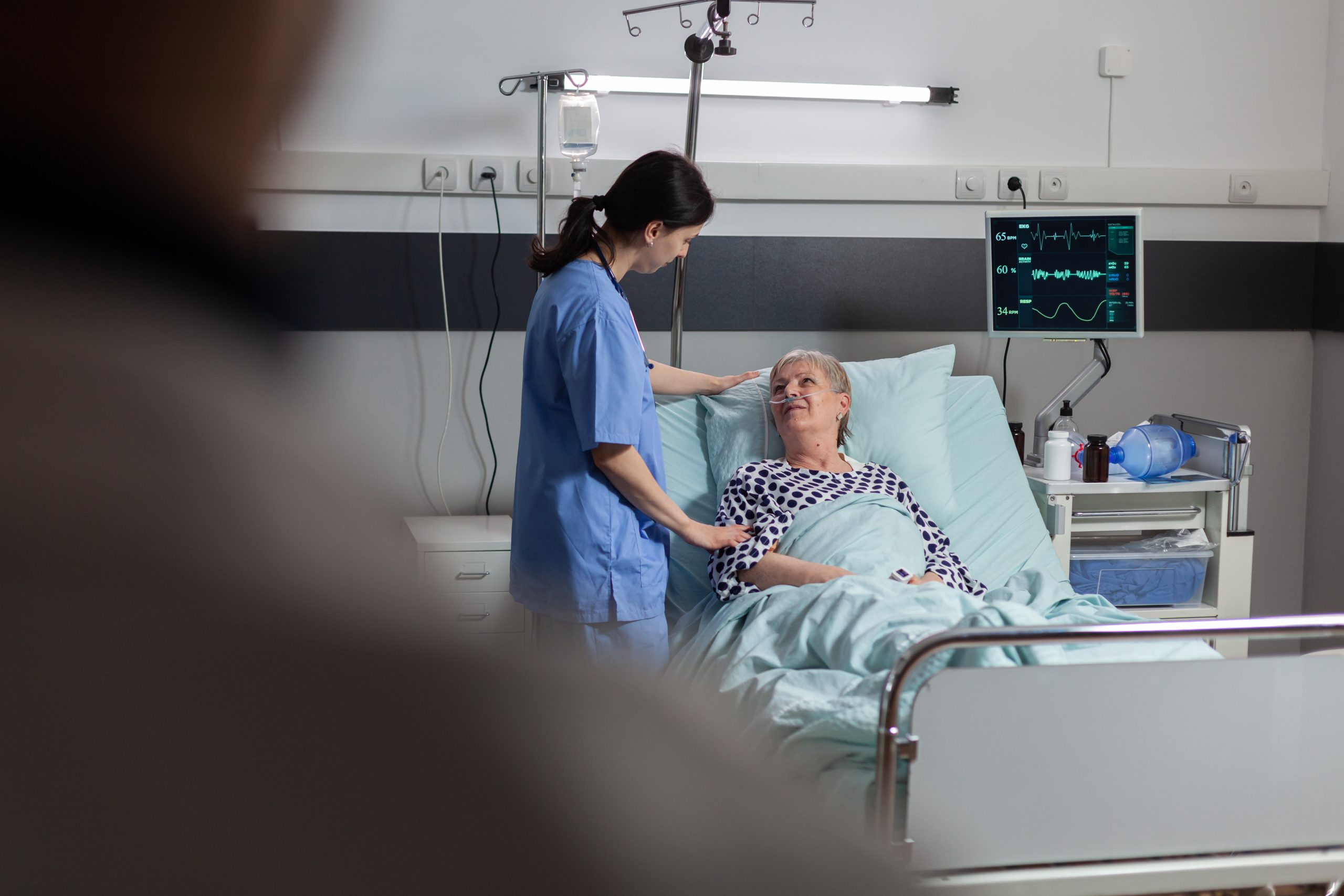 Sanitaria atendiendo a una paciente hospitalizada