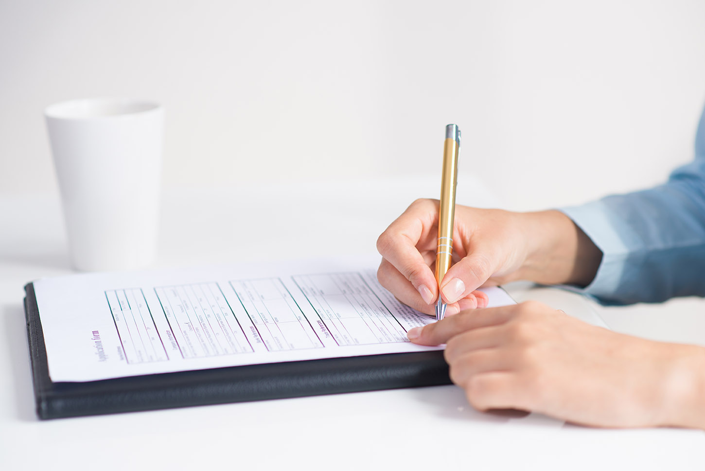 Manos de mujer rellenando un formulario de matriculación a mano